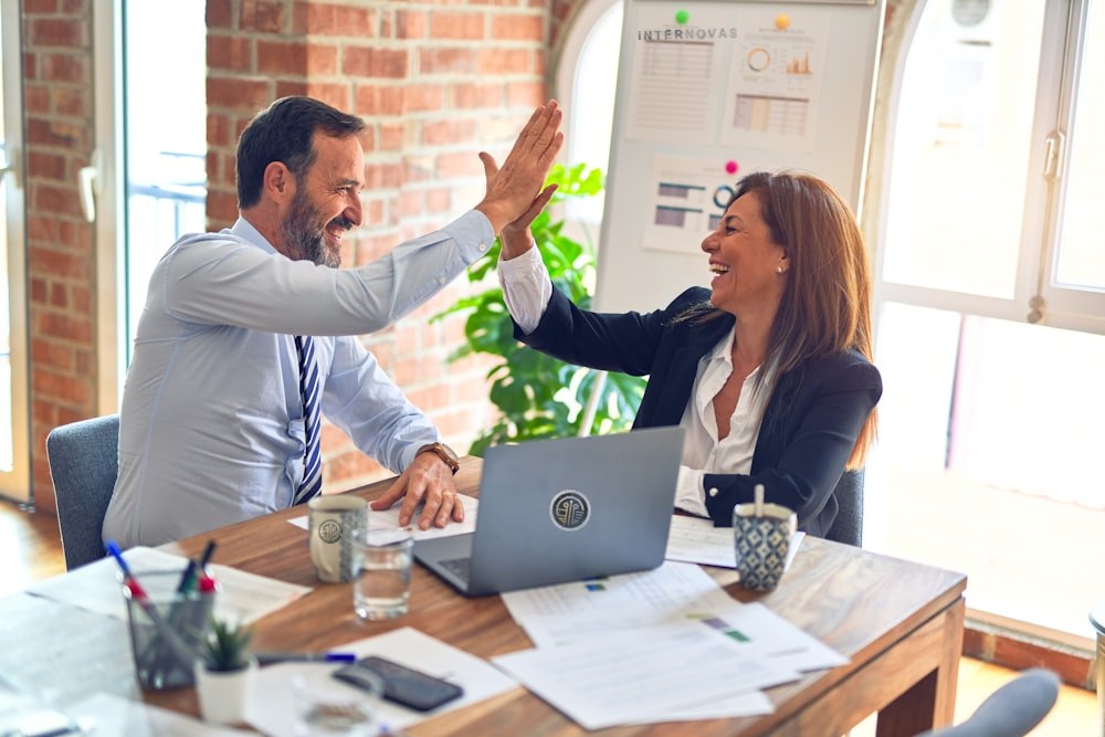Account manager and partner celebrating results in the office